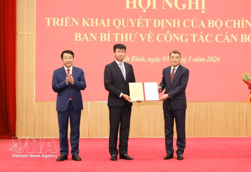 Le Minh Hung, miembro del Buró Político, secretario del Comité Central del Partido y jefe de su Comisión de Organización, entrega la decisión a Tran Huy Tuan. (Foto: VNA)